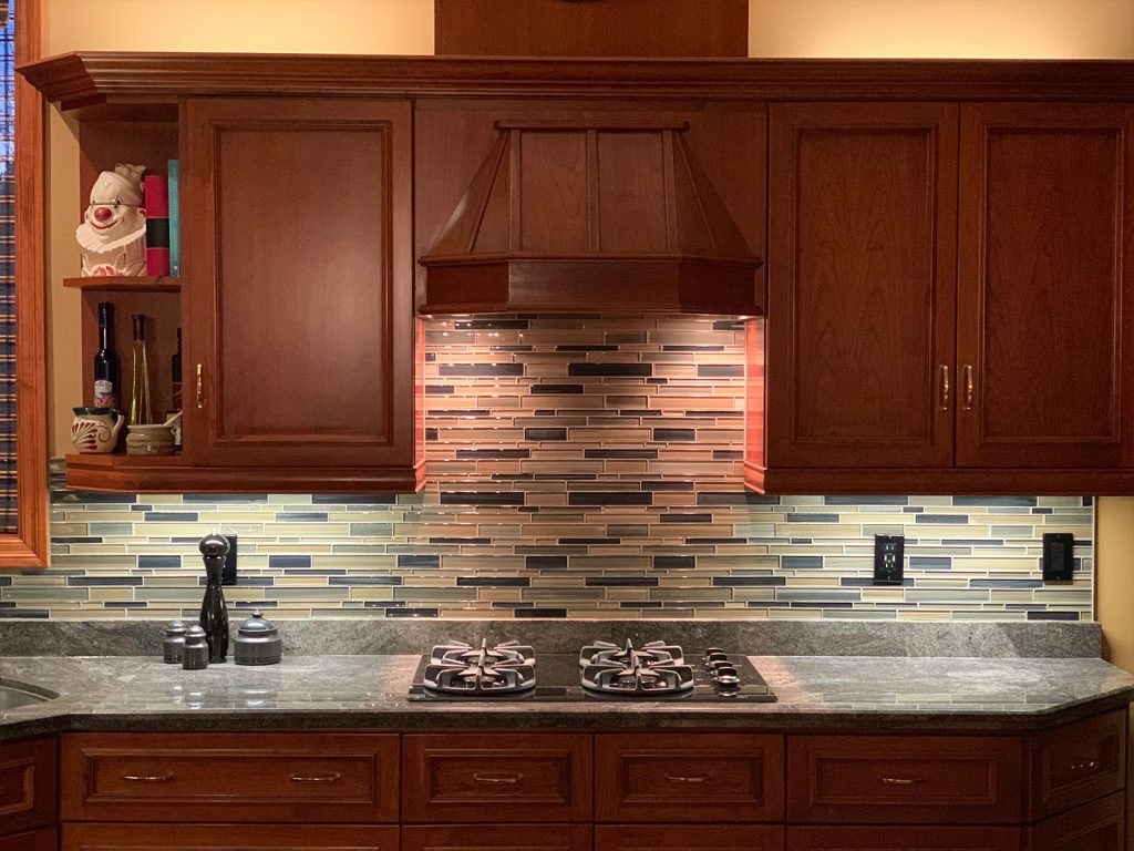 Cherry cabinets with glass back splash and granite countertop